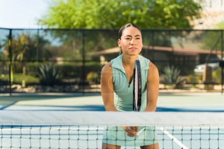 Foto de Deportiva mujer latina activa jugando un partido de tenis con un amigo mientras entrena para un juego al aire libre - Imagen libre de derechos