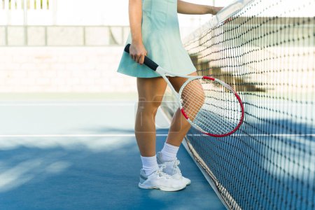 Foto de Primer plano de una joven mexicana sosteniendo una raqueta de tenis mientras se prepara para un partido al aire libre en la cancha de tenis - Imagen libre de derechos