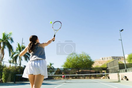 Foto de Chica adolescente activa divertida jugando un juego de tenis con un amigo al aire libre mientras hace ejercicio durante un entrenamiento - Imagen libre de derechos