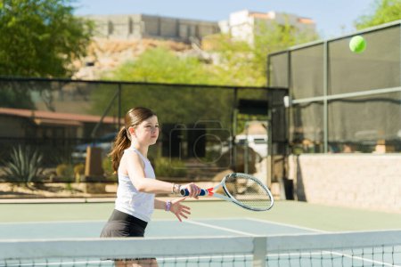 Téléchargez les photos : Adolescente caucasienne active jouant un match de tennis avec un ami pendant l'entraînement et l'exercice - en image libre de droit