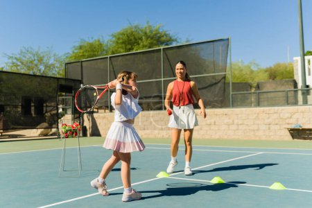 Téléchargez les photos : Belle ado caucasienne pratiquant son revers avec son entraîneur de tennis et s'entraînant - en image libre de droit