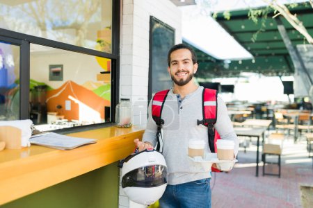 Photo for Happy man and delivery person at the cafe restaurant with the order to go looking cheerful smiling - Royalty Free Image
