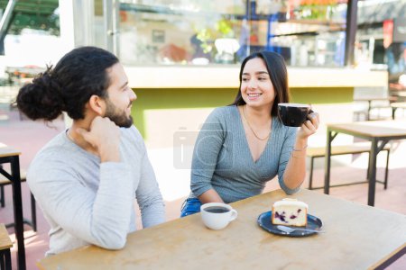 Foto de Alegre pareja atractiva riendo y hablando durante una cita divertida en el café al aire libre y beber café - Imagen libre de derechos