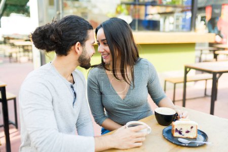 Téléchargez les photos : Couple heureux romantique dans la vingtaine se sentant amoureux tout en mangeant un dessert et en buvant du café ensemble pendant une date - en image libre de droit