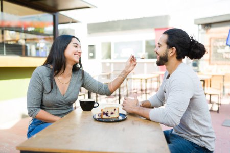 Téléchargez les photos : Beau petit ami attrayant et petite amie appréciant manger un dessert et boire du café pendant un rendez-vous romantique - en image libre de droit