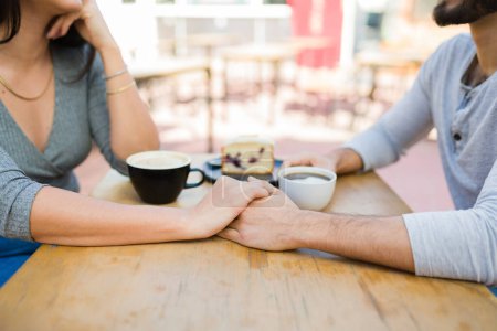 Téléchargez les photos : Couple romantique amoureux se tenant la main et parlant pendant un rendez-vous amusant boire du café au café - en image libre de droit