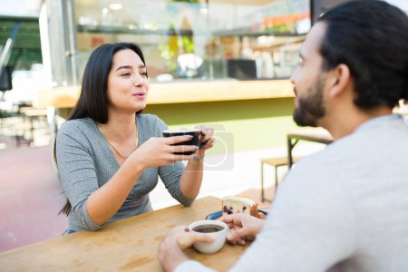 Téléchargez les photos : Latine belle jeune femme parler avec son copain pendant un rendez-vous tout en appréciant boire du café ensemble - en image libre de droit