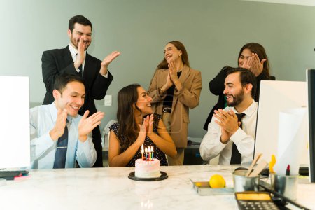 Foto de Empresarios y compañeros de trabajo celebrando un cumpleaños y comiendo pastel juntos en una oficina - Imagen libre de derechos