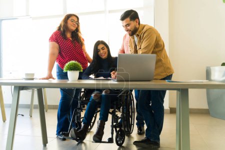 Téléchargez les photos : Belle femme handicapée en fauteuil roulant lisant un contrat avant de signer avec quelques hommes d'affaires - en image libre de droit