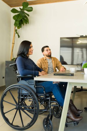 Photo for Full length view of a businesswoman in a wheelchair paying attention during a business meeting - Royalty Free Image