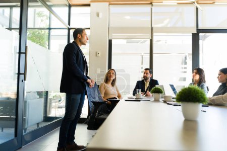 Téléchargez les photos : Homme d'affaires partageant sa proposition de travail avec certains clients dans une salle de réunion - en image libre de droit