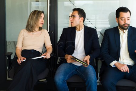 Photo for Candidates for a job position waiting for their interview and talking to each other in the meantime - Royalty Free Image