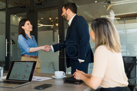 Foto de Linda mujer de negocios saludando a un cliente y dándole la mano en una sala de reuniones - Imagen libre de derechos
