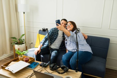 Téléchargez les photos : Femme hispanique prendre un selfie avec son invité heureux après l'enregistrement d'un épisode de podcast ensemble - en image libre de droit