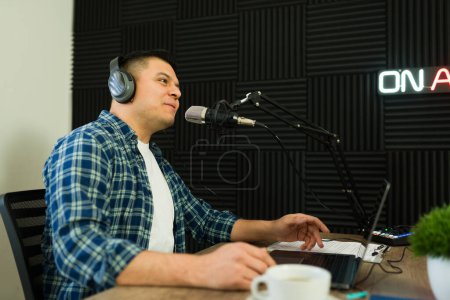 Photo for Attractive happy broadcast man enjoying talking during his podcast recording or radio show - Royalty Free Image
