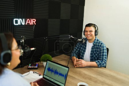 Téléchargez les photos : Beau podcast hispanique joyeux invité souriant tout prêt à commencer son interview à l'émission de radio talk - en image libre de droit