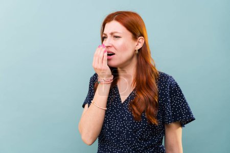 Photo for Worried caucasian redhead woman with bad breath and sick with mouth halitosis - Royalty Free Image