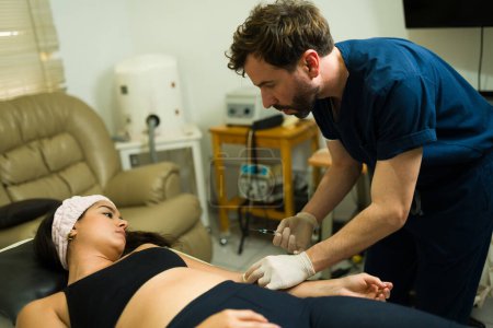 Téléchargez les photos : Femme hispanique recevant un traitement régénératif avec des injections de PRP plasmatique à la clinique de bien-être alternatif - en image libre de droit