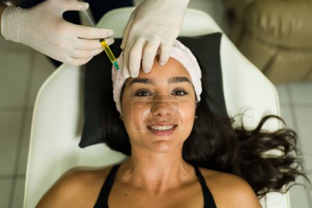 Téléchargez les photos : Portrait d'une femme hispanique joyeuse heureuse d'obtenir un traitement alternatif régénératif et de mettre des injections de plasma à la clinique - en image libre de droit