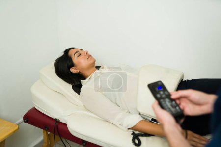 Foto de Paciente relajado recibiendo un masaje de vibración biofísica en la clínica de bienestar y utilizando la máquina de curación - Imagen libre de derechos