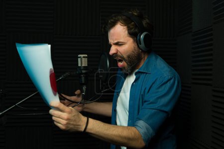 Intense male voice actor recording script with emotion in a professional studio setting