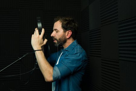 Photo for Male audio technician fine-tuning a studio microphone for recording - Royalty Free Image