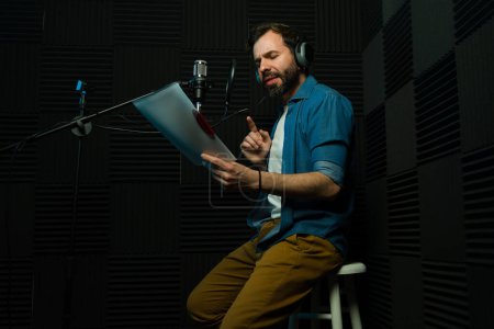 Male voice talent actively recording in a professional soundproof studio