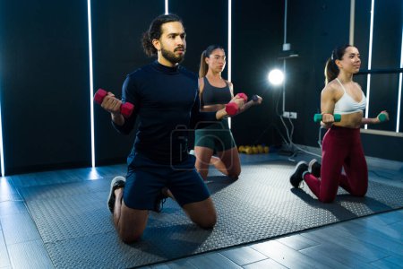 Foto de Los adultos realizan ejercicios con pesas en una clase de fitness moderna - Imagen libre de derechos