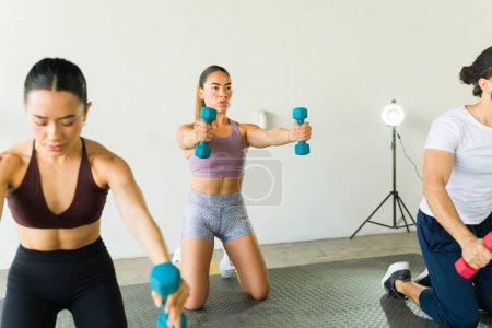 Téléchargez les photos : Personnes participant à une séance d'entraînement utilisant des poids - en image libre de droit