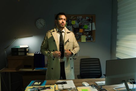 Foto de Retrato de un detective enfocado parado en una oficina oscura, examinando pistas y resolviendo un crimen - Imagen libre de derechos