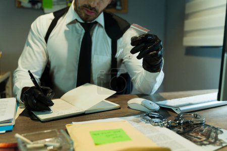 Photo for Private investigator looking at some drug pills as part of evidence in a case while wearing gloves, seen up close - Royalty Free Image