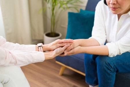 Photo for Compassionate female therapist offers support and understanding to her client, holding her hands during a therapy session - Royalty Free Image