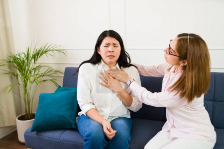 Female therapist providing support to a patient during therapy, helping her with some breathing exercises to calm down