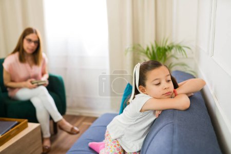 Photo for Young girl having therapy with a child psychologist but being difficult and avoiding talking to her therapist - Royalty Free Image