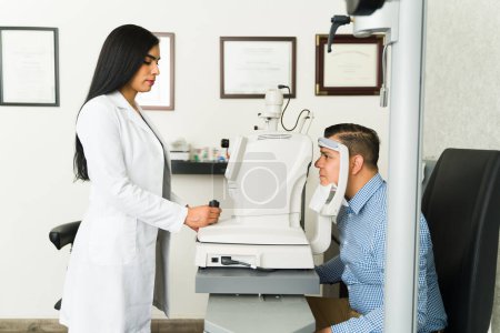Experienced ophthalmologist performing a thorough eye exam using advanced technology in a contemporary medical facility with a attentive patient