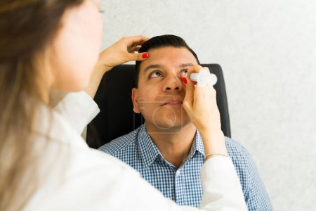 Experienced ophthalmologist using a syringe to remove a tear duct obstruction on a patient in a contemporary medical facility