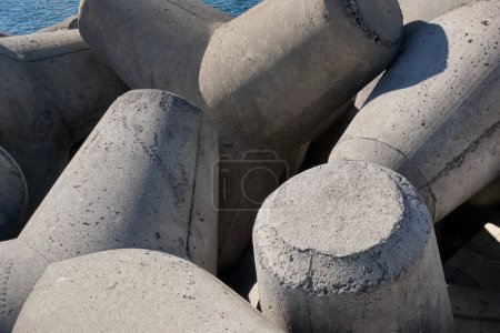 Téléchargez les photos : Close-up on the concrete structure Tetrapods. Concrete for hydraulic structures. Concrete breakwaters on the beach - en image libre de droit