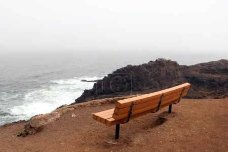 Photo for An empty bench on the coast of the sea or ocean. Relax - Royalty Free Image