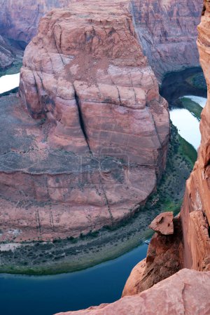 Téléchargez les photos : Un homme se tient sur le bord d'une falaise, regardant une rivière en contrebas. Le terrain accidenté et la vaste étendue d'eau créent un contraste frappant dans ce paysage pittoresque. - en image libre de droit