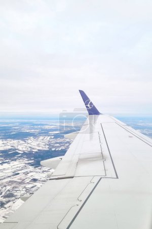 Photo for London, United Kingdom, February 25, 2024: The image showcases a clear view of an airplanes wing as it soars through the sky. The wing is positioned against the backdrop of the vast blue sky, highlighting the marvel of modern aviation. - Royalty Free Image