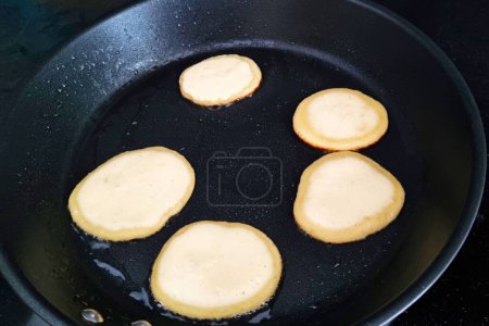 Delicious Mini Pancakes Cooking in a Black Non-Stick Pan.