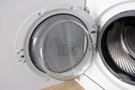 Front-loading washing machine with an open door showcasing modern design and functionality. ideal for efficient home laundry use, focusing on innovation, convenience, and hygiene in household appliances.