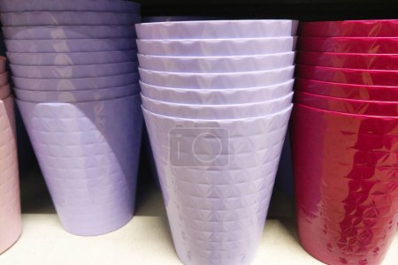 Neatly stacked plastic cups in pastel lavender and bright pink colors with a textured pattern, ideal for parties, gatherings, and everyday use. perfect for adding a pop of color to any event or kitchen, these cups offer both style and practicality.