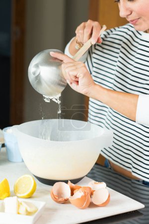Photo for Woman kneading the dough while cooking apple pie in the modern kitchen - Royalty Free Image