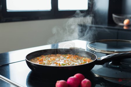 Téléchargez les photos : Steaming vegetable stew in a pan at the modern kitchen - en image libre de droit