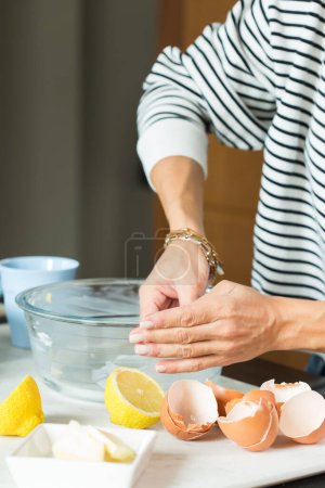 Photo for Woman greasing the baking dish while cooking apple pie in the modern kitchen - Royalty Free Image