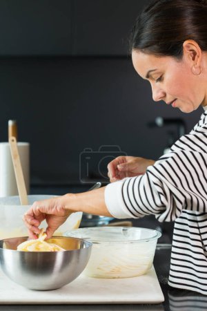 Photo for Woman putting apples while cooking apple pie in the modern kitchen - Royalty Free Image