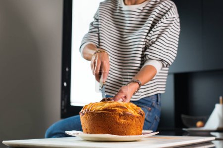 Téléchargez les photos : Young beautiful woman cutting homemade apple pie at the modern kitchen - en image libre de droit