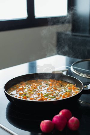 Téléchargez les photos : Steaming vegetable stew in a pan at the modern kitchen - en image libre de droit