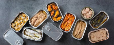 Photo for Assortment of different canned preserved fish and seafood in tin cans ready for tinned fish date night. Cheap and lowbrow food during economic crisis and inflation, banner - Royalty Free Image
